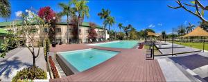 a large swimming pool in front of a building at Luisita Central Park Hotel in Tarlac