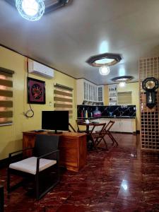 a living room with a desk and a table and chairs at D' ALORA Transient House in Daet
