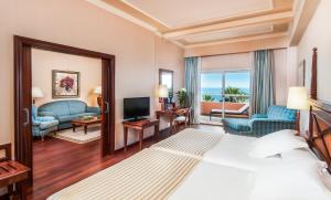 
a hotel room with two beds and a television at Elba Estepona Gran Hotel & Thalasso Spa in Estepona
