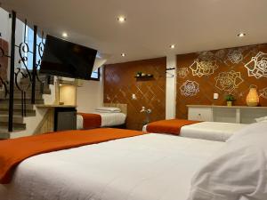 Un dormitorio con dos camas y un televisor de pantalla plana. en Hotel RioMiel Tlaxcala, en Tlaxcala de Xicohténcatl