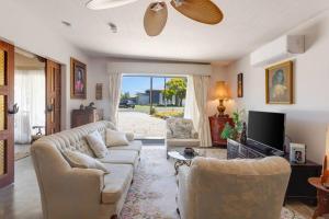 a living room with two couches and a tv at Shangri La in Goolwa South