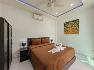 a bedroom with a bed with a white swan on it at CHATEAU DALE POOL VILLA 177 nearby WALKING STREET in Pattaya South