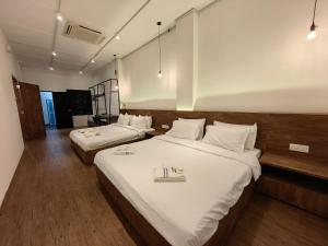 una camera d'albergo con due letti con lenzuola bianche di Kangsar Inn 73 a George Town