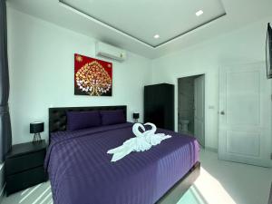 a bedroom with a purple bed with a towel on it at CHATEAU DALE POOL VILLA 177 nearby WALKING STREET in Pattaya South