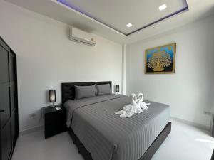 a bedroom with a bed with a white flower on it at CHATEAU DALE POOL VILLA 177 nearby WALKING STREET in Pattaya South