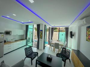 un salon avec une table et des chaises et une cuisine dans l'établissement CHATEAU DALE POOL VILLA 177 nearby WALKING STREET, à Pattaya (sud)