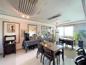 a living room with a table and chairs at HY Choi Hostel in Seogwipo