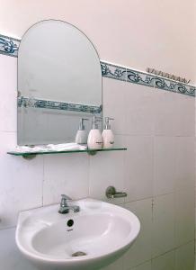 a bathroom with a sink and a mirror at Le Condor 's House & Coffee in Con Dao