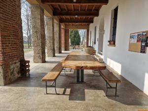 a row of wooden tables in a building at B&B e Ostello, Parco di Monza, CASCINA COSTA ALTA in Monza
