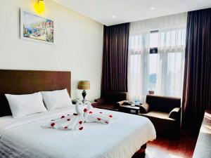 a hotel room with a bed with red roses on it at Bình Minh Hotel in Hà Tĩnh