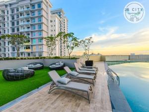 a row of chaise lounge chairs on a patio with a pool at Paradigm Residence by JBcity Home in Johor Bahru