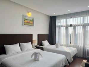 a hotel room with two beds and a window at Bình Minh Hotel in Ha Tinh