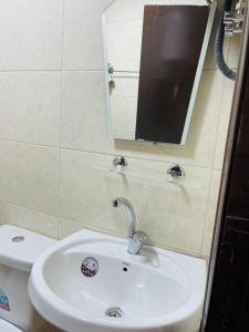 a bathroom with a sink and a mirror and a toilet at Grandpa House in Wadi Musa