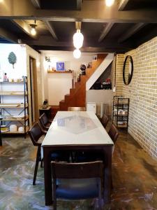 木浦市にあるYachtie Inn Mokpoのテーブルと椅子、階段が備わる客室です。