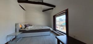 una camera da letto con un letto e una grande finestra di Yachtie Inn Mokpo a Mokpo