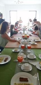a group of people sitting at a long table with plates of food at Kandy Unique Hotel in Kandy