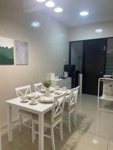 un tavolo bianco e sedie in cucina di HEAL Rafflesia Sentul w pool view 9 pax 3 BR All AC a Kuala Lumpur