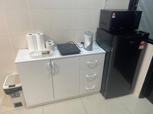 una cucina con frigorifero nero e armadietti bianchi di HEAL Rafflesia Sentul w pool view 9 pax 3 BR All AC a Kuala Lumpur
