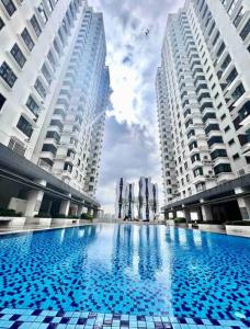 una grande piscina al centro di due edifici di HEAL Rafflesia Sentul w pool view 9 pax 3 BR All AC a Kuala Lumpur