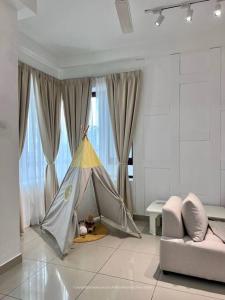 una tenda in un soggiorno con divano di HEAL Rafflesia Sentul w pool view 9 pax 3 BR All AC a Kuala Lumpur