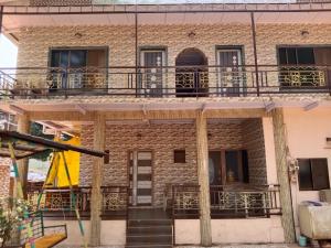 a brick building with balconies on top of it at Alpha House Matheran in Matheran