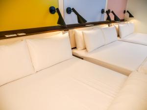- une rangée de lits dans une chambre avec des oreillers blancs dans l'établissement MF Hotel, penghu, à Magong