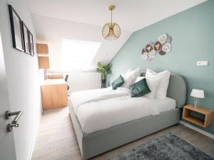 1 dormitorio con 1 cama con pared azul en Deluxe Suite - Living & Work Place en Gießen