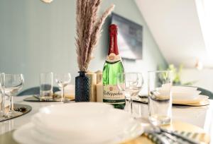 a table with a bottle of wine and plates and glasses at Deluxe Suite - Living & Work Place in Gießen