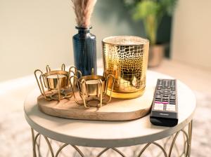 uma mesa com um vaso e um controlo remoto em Deluxe Suite - Living & Work Place em Giessen