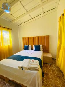 a bedroom with a large bed with towels on it at Villa Marcia in Boca Chica