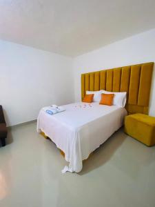 a bedroom with a large white bed with orange pillows at Villa Marcia in Boca Chica +120 photos