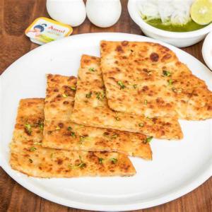 a white plate of food on a wooden table at Gold Nest Rubystone Heritage in Udaipur