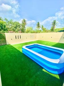 a blue and white inflatable swimming pool on green grass at Medina Homestay Chukai Kemaman in Cukai