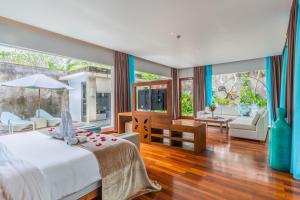 um quarto com uma cama e uma sala de estar em The Leaf Jimbaran Luxury Villas em Jimbaran