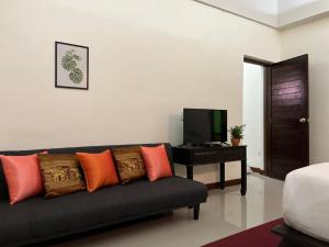 uma sala de estar com um sofá e uma televisão em Rainforest Huahin Village Hotel em Hua Hin