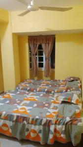 um quarto com uma cama com um edredão colorido em El Rincón del Ángel Tuxpan em Tuxpan de Rodríguez Cano