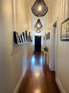 um quarto com um corredor com um lustre e um piso de madeira em Entire contemporary home in Ascot Vale em Melbourne