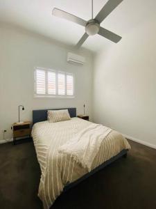 sypialnia z łóżkiem i wentylatorem sufitowym w obiekcie Entire contemporary home in Ascot Vale w Melbourne