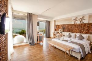 - une chambre avec un grand lit et une table dans l'établissement Jimbaran Bay Beach Resort and Spa by Prabhu, à Jimbaran