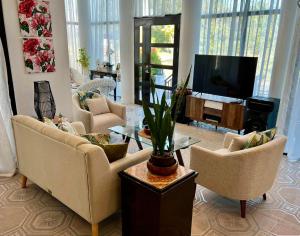 a living room with couches and a flat screen tv at Big & Homey in exclusive village in Davao City