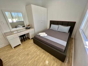 a bedroom with a bed with a desk and a window at Big & Homey in exclusive village in Davao City