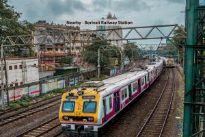 a yellow and pink train is on the tracks at Super Hotel O Palace Inn Near Don Bosco (Borivali) Metro Station in Mumbai +25 photos