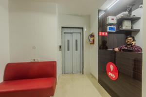 ein Wartezimmer mit einem roten Stuhl und einem Spiegel in der Unterkunft Hotel Palace Inn Near Don Bosco -Borivali- Metro Station in Mumbai
