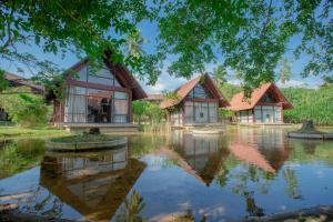 une maison avec un étang en face de celle-ci dans l'établissement Celestia Wellness Resort, à Bentota