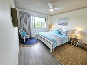 a bedroom with a large bed and a window at Ocean Crest On Pebbly - Winner 2024 Traveller Awards! in Forster