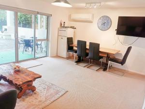a dining room with a table and chairs and a television at Lakeside & Tennis Court Paradise in Rotorua