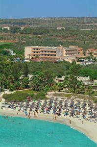 a beach with a bunch of umbrellas and people on it at Nissiana Hotel & Bungalows in Ayia Napa