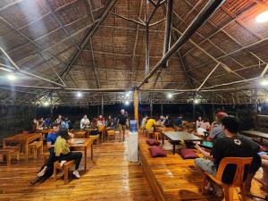 a group of people sitting at tables in a restaurant at Dam Dam Place in San Vicente