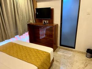 a hotel room with a bed and a television at Hotel Belmond Prime- Near NESCO in Mumbai