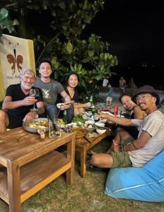 een groep mensen die rond een tafel zitten met eten bij You retreat in Quy Thượng